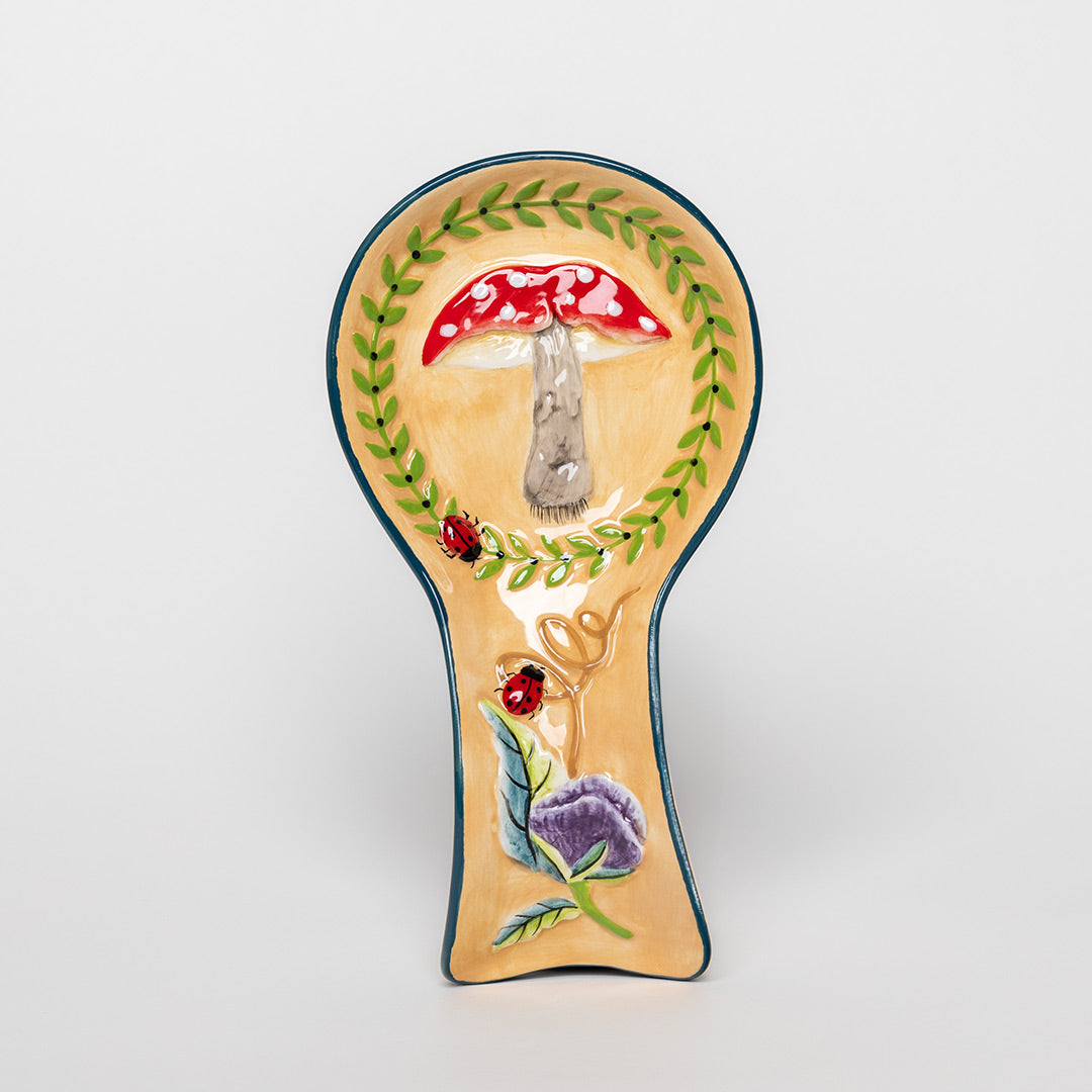 Handcrafted mushroom spoon rest on kitchen counter with wooden spoon